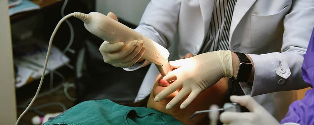 a dentist takes digital impressions of a person's teeth