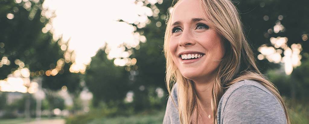 a woman smiles confusedly as she considers what endodontic treatment is