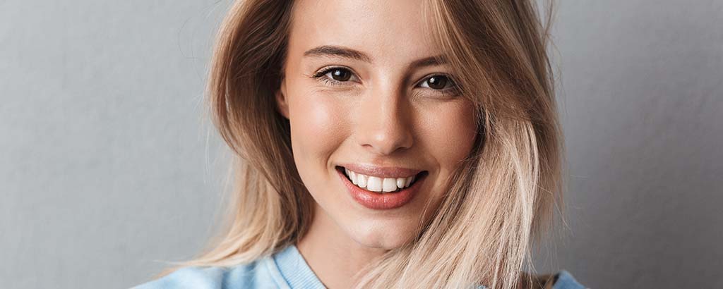 a woman smiles after getting fillings