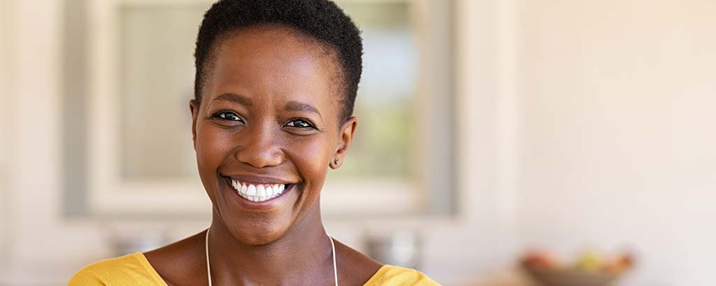 a woman smiles after receiving occlusal disease treatment