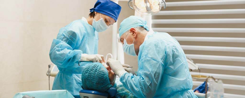 a pair of dentists perform oral surgery