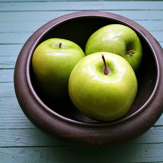 apples in a bowl remind viewer of foods that naturally whiten your teeth