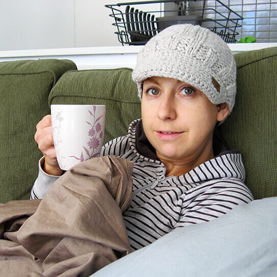 a woman drinks tea and thinks about how to protect your teeth this cold and flu season