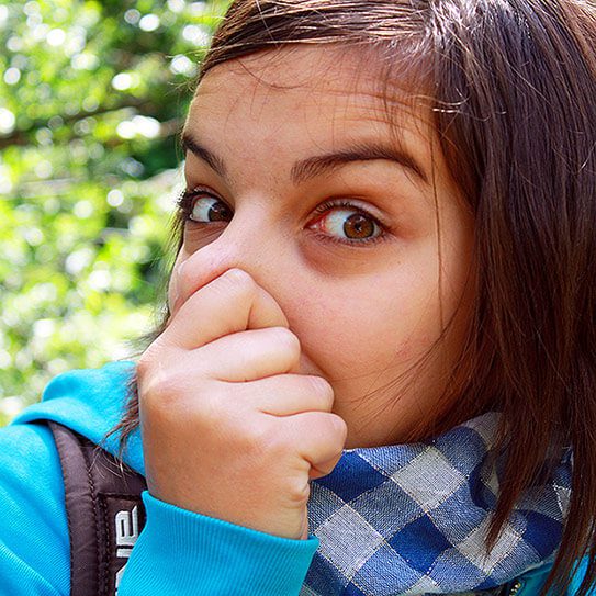 a woman holds her nose as she considers the delicate balance of oral bacteria