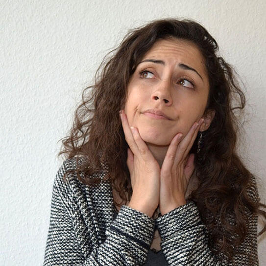 a woman looks off pensively as she thinks about how to choose a great dentist