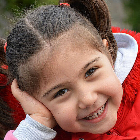 a little girl smiles as she seals out plaque with sealants