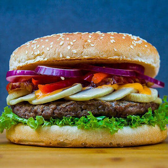a large burger makes the viewer wonder about oral health and eating disorders